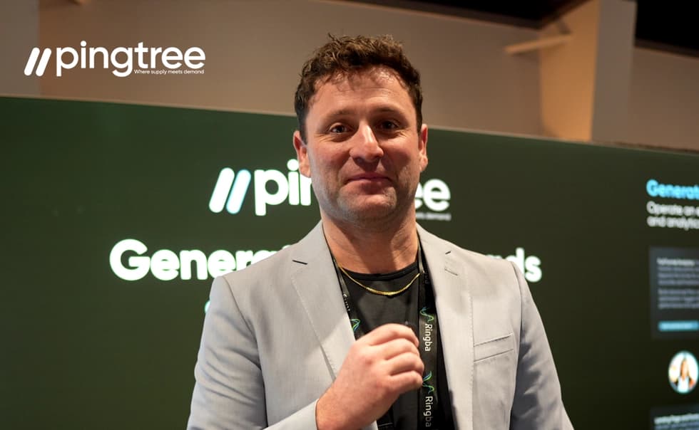 Man in a light gray blazer stands in front of a green backdrop with "pingtree" logo, smiling at the camera.