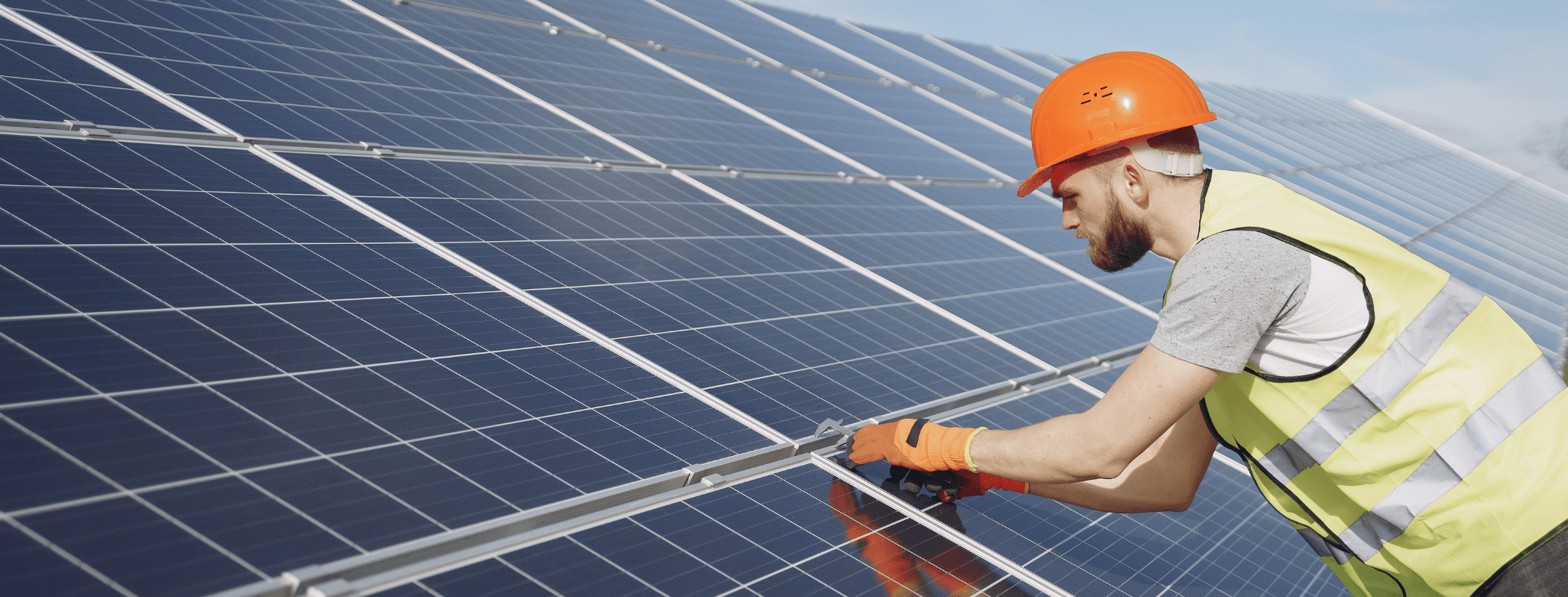 Worker installing solar panel on rooftop